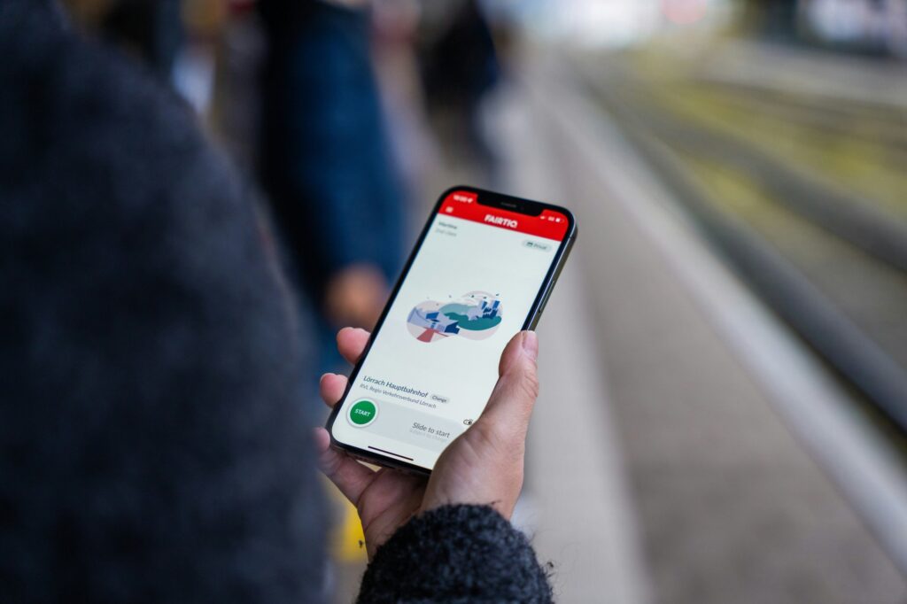 Passenger booking a taxi on a smartphone at a station platform