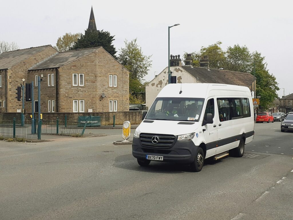 White Mercedes Sprinter minibus on a street in Bradford